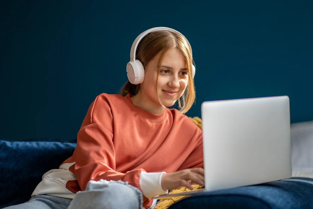Kindersicherung - zeigt ein Mädchen vor einem Notebook